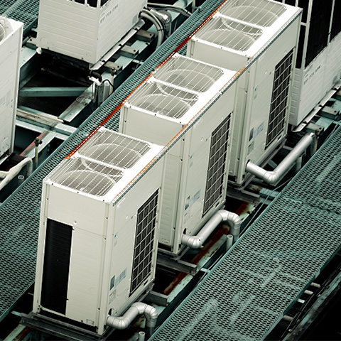 ビルの屋上に整然と並ぶ業務用エアコンの室外機群